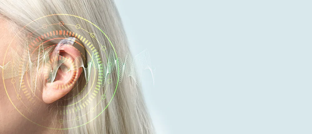 Mature,Woman,With,Hearing,Aid,On,Light,Background,With,Space